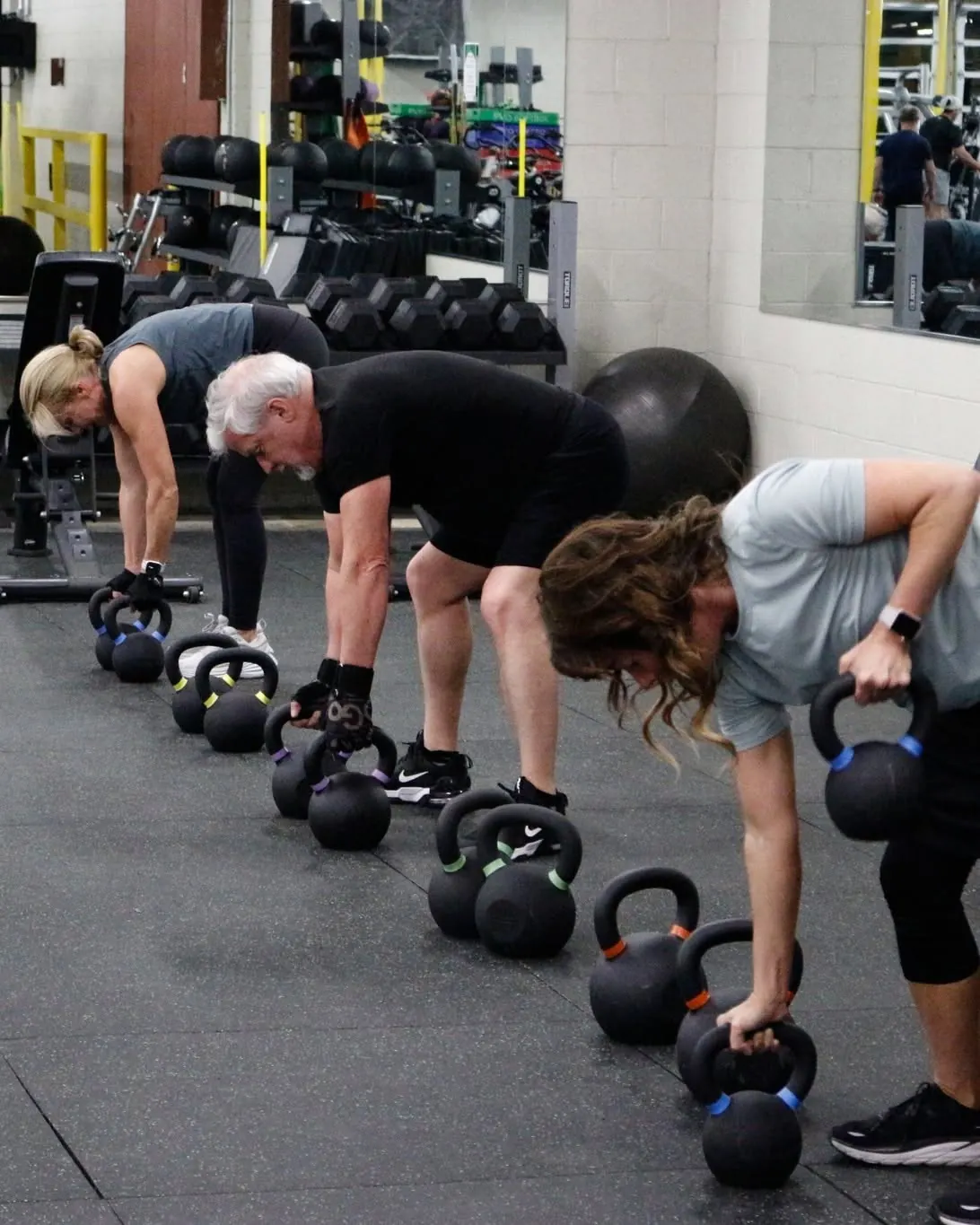 Members doing kettlebell rows together in a Downtown Gym group class