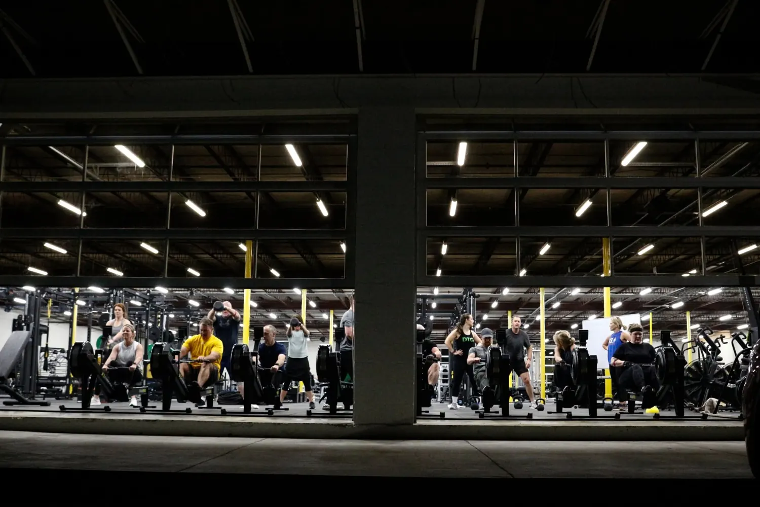 The Downtown Gym training floor lit up at night, members working out
